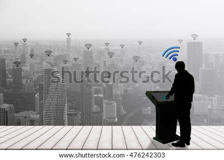 Silhouette good business or working man touch finger on computer to connect to wifi network connection on black tone city scape abstract background. wifi 4G 5G 3G network concept. web social community