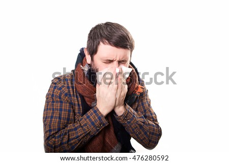 young sick and ill man in bed holding tissue cleaning snotty nose having temperature feeling bad infected by winter grippe virus in flu and influenza health care concept. Royalty-Free Stock Photo #476280592
