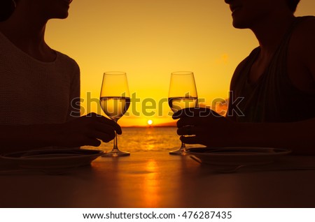 Romantic couple enjoying a glass of wine and a beautiful sunset. 