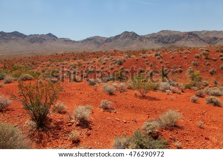 Dry dessert landscape with red rocks