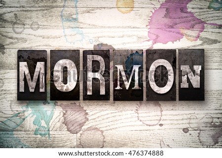 The word "MORMON" written in vintage, dirty metal letterpress type on a whitewashed wooden background with ink and paint stains.