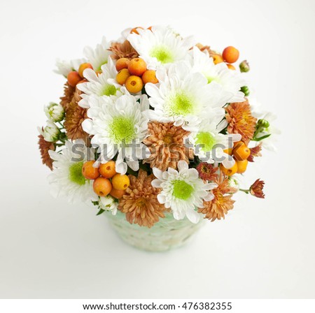 Bouquet with chrysanthemums in a basket. The isolated object on a light background. Selective focus