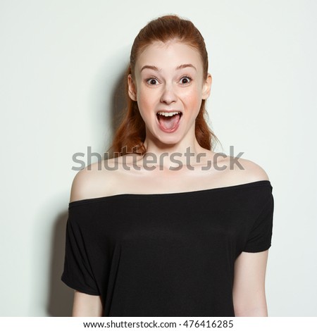 Emotional beauty portraits red-haired girl. On a neutral background.