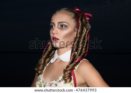 glamour zombie girl with ringlets as at a doll  . Halloween concept. black background. Halloween make up.