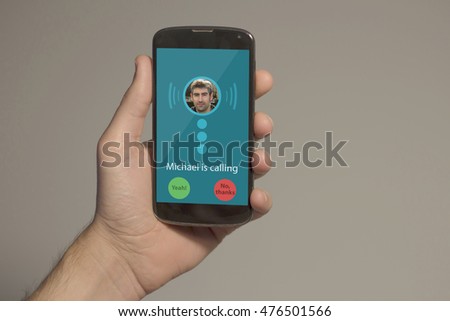  Hand holding smartphone with incoming call on the screen. All screen graphics are made up.