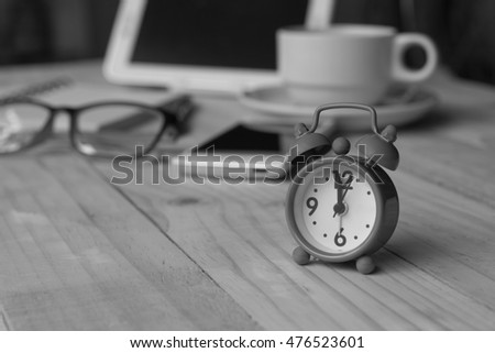 Black and white picture alarm clock on his desk.