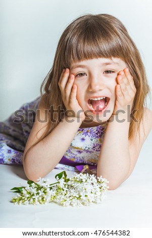 Cheerful kid in the white room with the flower