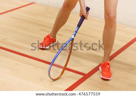 A young female squash player in a squash court
