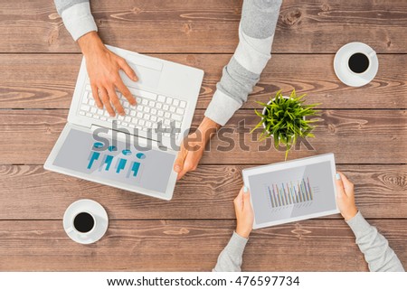 Man and woman working on computer and tablet in office