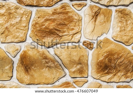Background of stone wall made with blocks on gold tone
