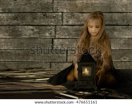 vintage, children. retro style. Pretty blond girl sitting on straw, and look at the Old Lantern