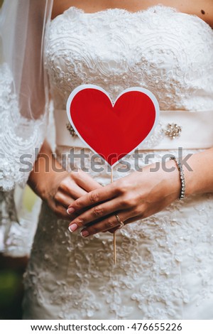 Couple show hearts card with text "Just Married". Outdoor picture.
