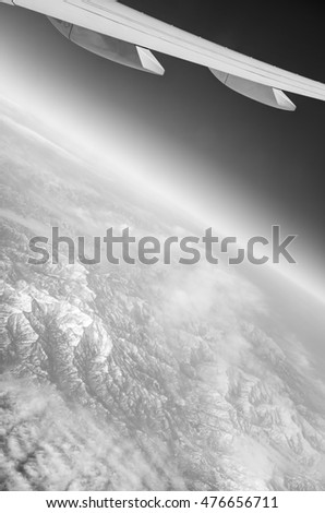 HDR black and white Aerial photo of the japanese landscape with clouds, mountains and landscape with snowy patches and a view stretching all the way to the horizon