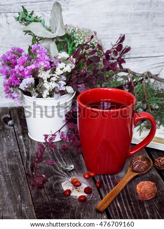 Red Cup on wooden background with wooden spoon and book