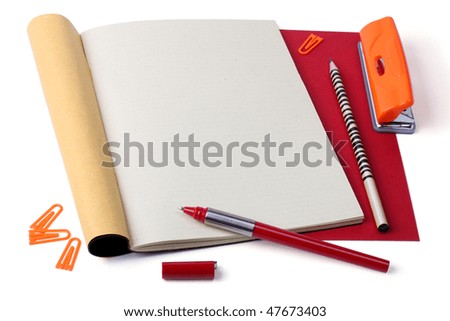 Open notebook with pen, pencil, paper clips and hole punch.