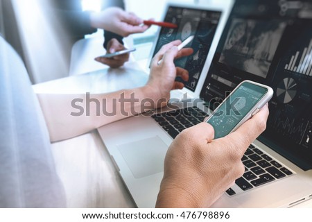 Photo website graphic designer hand working with his team make new project in studio.Modern laptop extend screen digital tablet smart phone on wood table. sun flare effect