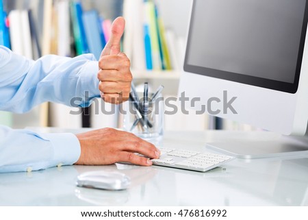Close up of Successful businessman's Hands showing thumbs up at Office Desktop
