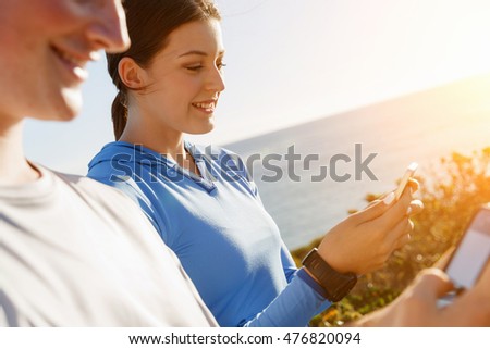 Young couple with smartphones outdoors