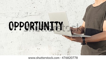 Young man using laptop and OPPORTUNITY concept on wall background