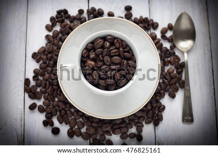 Coffee beans in cup on rustic table