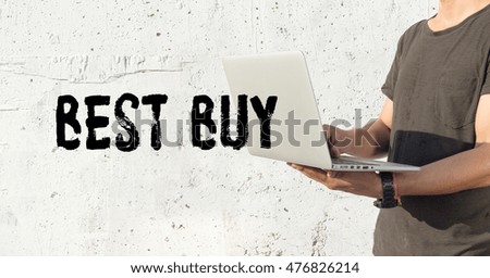 Young man using laptop and BEST BUY concept on wall background