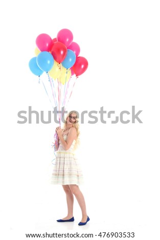 Full length portrait of a pretty blonde girl wearing a white dress, holding a bunch of colourful balloons. Isolated on what background.