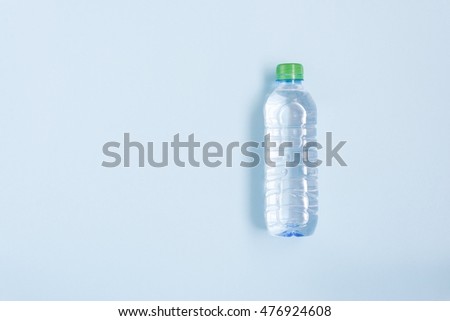 Bottle with clean water over blue background, top view Royalty-Free Stock Photo #476924608