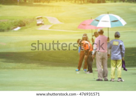 Many golfers on the golf course with the morning sunshine