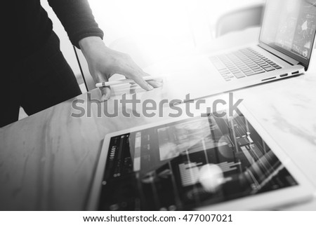 Businessman hand touching digital tablet.Photo finance manager working new Investment project office.Using new technology device.Graphic icons.Strategy business stock exchanges, black white

