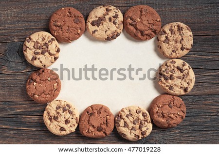 Cookies with chocolate and nuts on old wooden background, top view. Space for text
