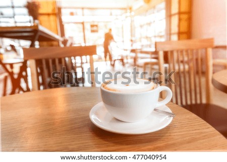 Cup of cappuccino with blur coffee shop background - vintage effect style pictures