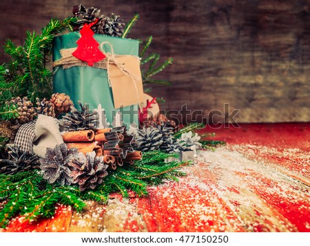 Happy New Year Composition. Cones, Fir Branches,Cinnamon Sticks in the Bag, Red Wooden Background.Snow, Vintage Style.Free Space for your text.