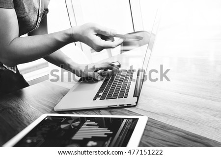 Businessman hand touching digital tablet.Photo finance manager working new Investment project office.Using new technology device.Graphic icons.Strategy business stock exchanges, black white
 
