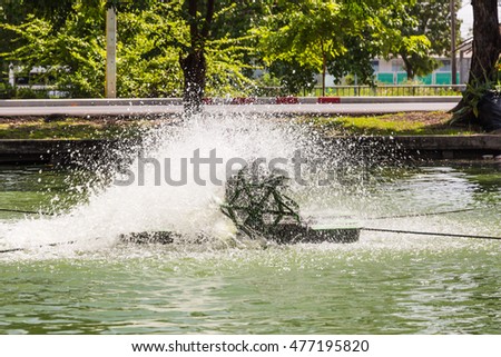 Paddlewheel water aeration is used to increase dissolved oxygen in water in the pond Royalty-Free Stock Photo #477195820