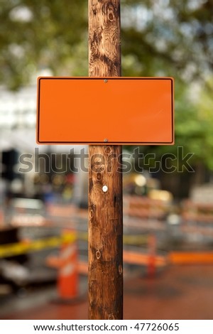 Blank orange construction sign,on wooden electric pole