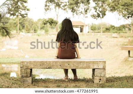 Alone concept : Alone girl sitting on a wooden chair