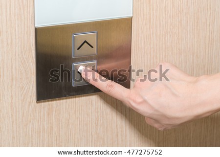 Young woman pressing elevator button
