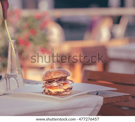 Tasty burger served on wooden in a traditional gourmet soft focus atmosphere terrace