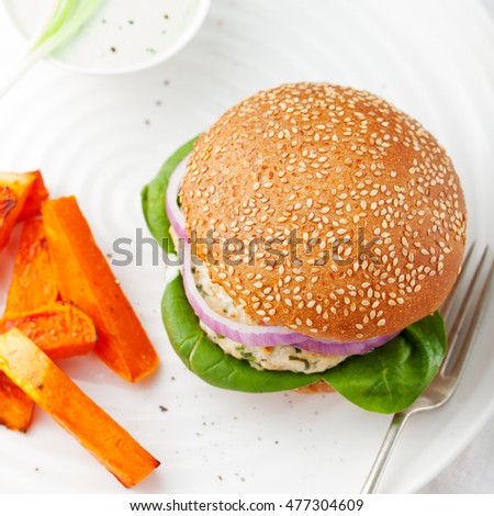 Burger with turkey, spinach, onion and roasted sweet potato, batat on a white background