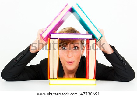 Successful funny curious business woman building house with a lot of books happy