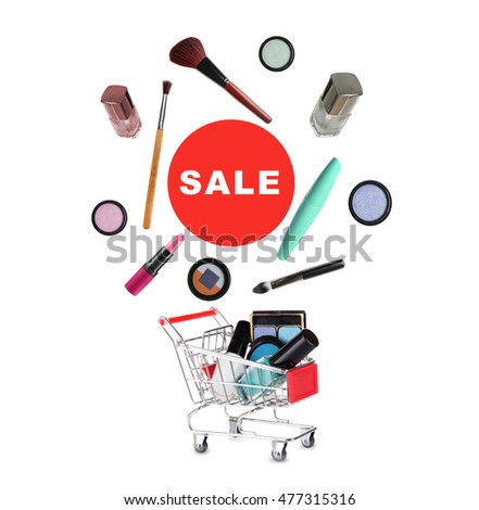 Cart with flying out cosmetics isolated on white