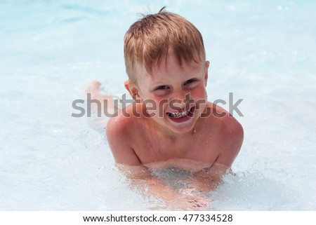 boy smiling and having fun in the pool