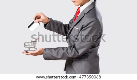 Grey suit asian business man holding credit card and small shopping cart for online shopping concept.