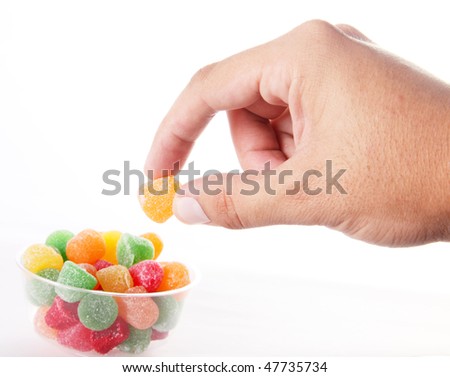 hand taking a candy over white background