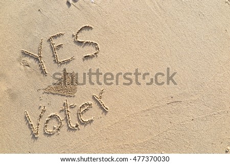 written words "YES Voter" on sand of beach