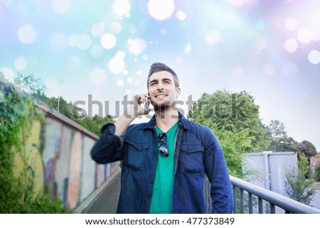 Young man talking on smartphone with glowing lights above