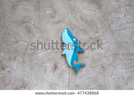 Homemade gingerbread cookie on the cake for the birthday in the shape of shark. Space for text and selective focus.