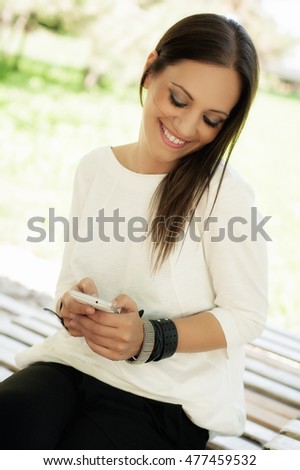Happy young woman using cell phone with smile and laughing