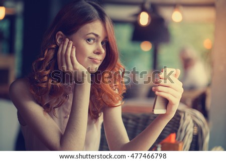woman with a telephone in the restaurant looking at phone