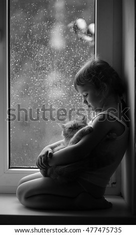 girl with cat at the window Royalty-Free Stock Photo #477475735
